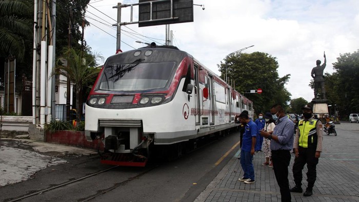 Warga menyeberangi jalan seusai menunggu kereta perintis atau Railbus Batara Kresna melintas di kawasan Gladak  Solo, Jawa Tengah, Rabu (9/3/2022). Kereta railbus dengan rute Stasiun Purwosari Solo- Stasiun Wonogiri tersebut dioperasikan PT KAI Daop 6 Yogyakarta sebagai transportasi alternatif bagi warga dengan tarif Rp4 ribu per penumpang guna meningkatkan pertumbuhan ekonomi dan mengurangi kepadatan jalan. ANTARAFOTO/Maulana Surya/aww.