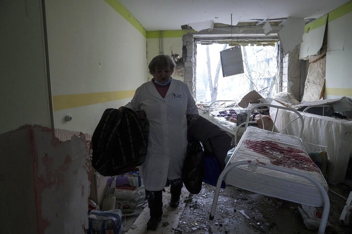 An injured pregnant woman walks downstairs in a maternity hospital damaged by shelling in Mariupol, Ukraine, Wednesday, March 9, 2022. (AP Photo/Evgeniy Maloletka)