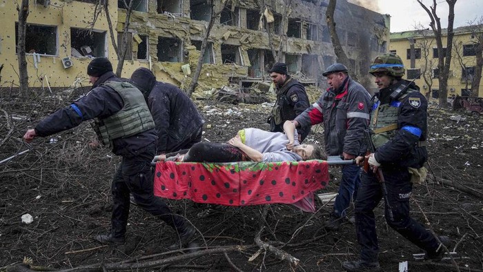 An injured pregnant woman walks downstairs in a maternity hospital damaged by shelling in Mariupol, Ukraine, Wednesday, March 9, 2022. (AP Photo/Evgeniy Maloletka)