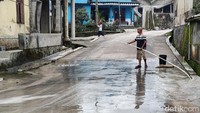 Abu vulkanik dibersihkan dengan cara diguyur air.