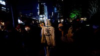 Seorang pengunjuk rasa yang mengenakan pakaian pelindung berjalan selama demonstrasi anti-nuklir di depan markas besar Tokyo Electric Power Co (TEPCO).