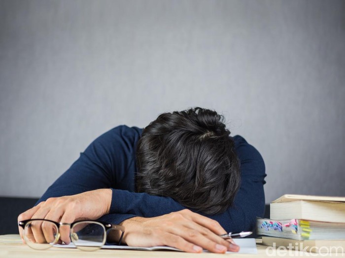 878879976 Man sleeping on work wooden desk, study hard and tired concept.