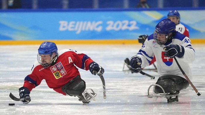 Czech Republic's Zdenek Krupicka, left, battles for the puck against Slovakia's Milos Vecerek during their para ice hockey preliminary round match at the 2022 Winter Paralympics, Tuesday, March 8, 2022, in Beijing. (AP Photo/Dita Alangkara)