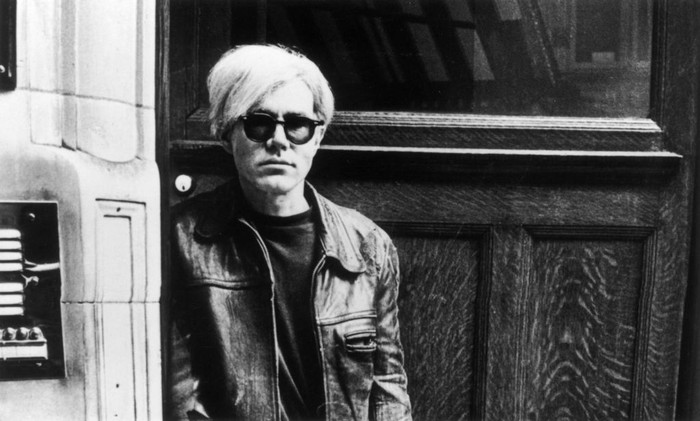 Andy Warhol Andy Warhol (1926 - 1987), American pop artist and filmmaker, holding an example of one of his posters. Original Publication: People Disc - HM0195 (Photo by John Minihan/Getty Images)
