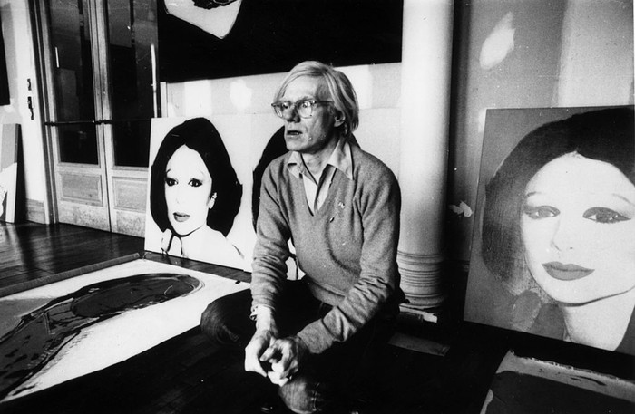 Andy Warhol Andy Warhol (1926 - 1987), American pop artist and filmmaker, holding an example of one of his posters. Original Publication: People Disc - HM0195 (Photo by John Minihan/Getty Images)
