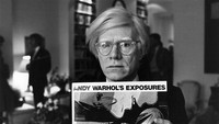 Potret Andy Warhol sedang memegang salah satu poster ciptaannya.  Foto: Getty Images/John Minihan