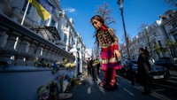 Boneka raksasa Little Amal meletakkan bunga di luar Kedutaan Besar Ukraina pada 10 Maret 2022 di London, Inggris.  Foto: Getty Images/Chris J Ratcliffe