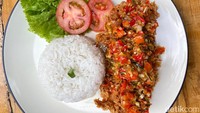 Ayam sambal matah buatan Dapoer Kebun dibuat dari fillet dada ayam goreng tepung. Siraman sambal matahnya yang pedas segar menyelimuti permukaan ayam.
