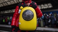 Seorang gadis Ukraina dan kucingnya menunggu di peron di dalam stasiun kereta api Lviv. (AP/Bernat Armangue)