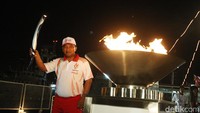 Icuk Sugiarto saat membawa api Obor Asian Games yang dihelat di Indonesia. 