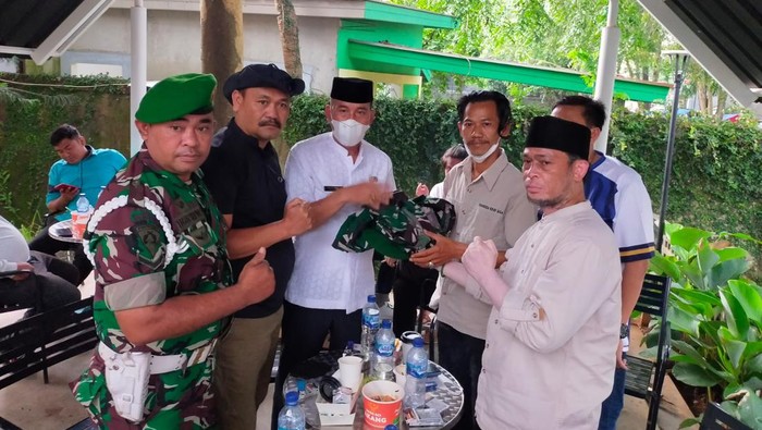 Kepala Desa Wanakerta (Tengah, baju putih) mengembalikan seragam TNI yang dipakai (dok.ist)