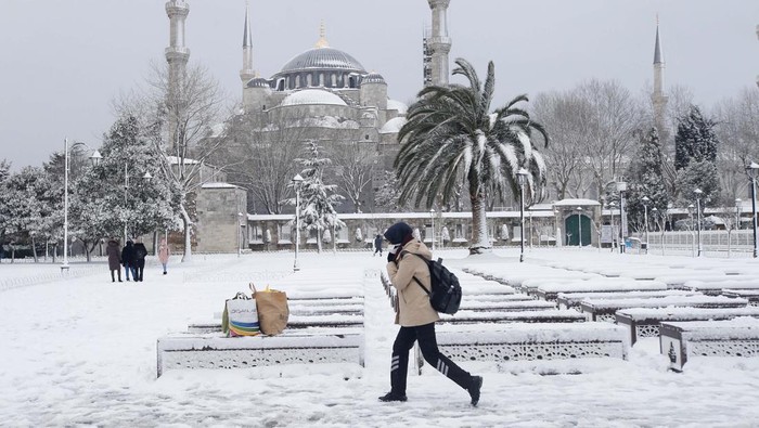 Ketika Masjid Biru Istanbul Tertutup Salju Putih A woman, with the Sultanahmet Mosque, known as the Blue Mosque in the background, makes her way during a snow storm in Istanbul, Turkey March 11, 2022. REUTERS/Dilara Senkaya
