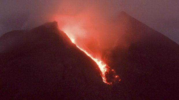 Lahar mengalir dari kawah Gunung Merapi terlihat dari desa Cangkringan di Sleman, Yogyakarta, Jumat dini hari (11/3/2022). Letusan Gunung Merapi di Indonesia berlanjut pada Jumat, memaksa pihak berwenang untuk menghentikan kegiatan pariwisata dan penambangan di lerengnya karena bahaya di gunung berapi paling aktif di negara ini. (AP Photo/Slamet Riyadi)