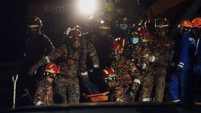 Longsor Landa Ampan Malaysia, 4 Orang Tewas Rescue workers carry out the body of a victim after a landslide was triggered by heavy rains in the township of Ampang, outside Kuala Lumpur early on March 11, 2022. (Photo by Arif Kartono / AFP)