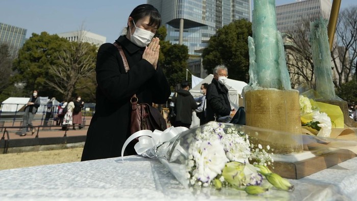 Peringatan 11 Tahun Gempa dan Tsunami Jepang A visitor prays at a makeshift altar to mourn for the victims of the March 11, 2011 earthquake and tsunami during a special memorial event Friday, March 11, 2022, in Tokyo. Japan on Friday marked the 11th anniversary of the massive earthquake, tsunami and nuclear disaster that struck Japan's northeastern coast. (AP Photo/Eugene Hoshiko)