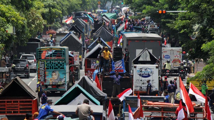 Deretan truk berbagai jenis terparkir saat sopir yang tergabung dalam Gerakan Sopir Jawa Timur (GSJT) berunjuk rasa di depan Kantor Dinas Perhubungan, Surabaya, Jawa Timur, Jumat (11/3/2022). Dalam aksinya mereka menuntut ketegasan pemerintah dalam penerapan kebijakan regulasi angkutan logistik terkait kelebihan muatan (over loading) dan dimensi (over dimension) angkutan truk barang. ANTARA FOTO/Patrik Cahyo Lumintu/Zk/nym.