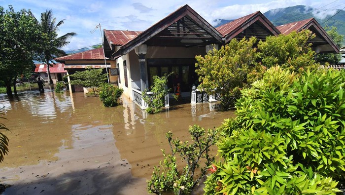 Warga berada di rumahnya yang terendam banjir di Palu, Sulawesi Tengah, Sabtu (12/3/2022). Hujan disertai angin kencang yang melanda daerah tersebut mengakibatkan sejumlah rumah warga terendam banjir, pohon tumbang dan satu bangunan sekolah rusak. ANTARA FOTO/Mohamad Hamzah/rwa.