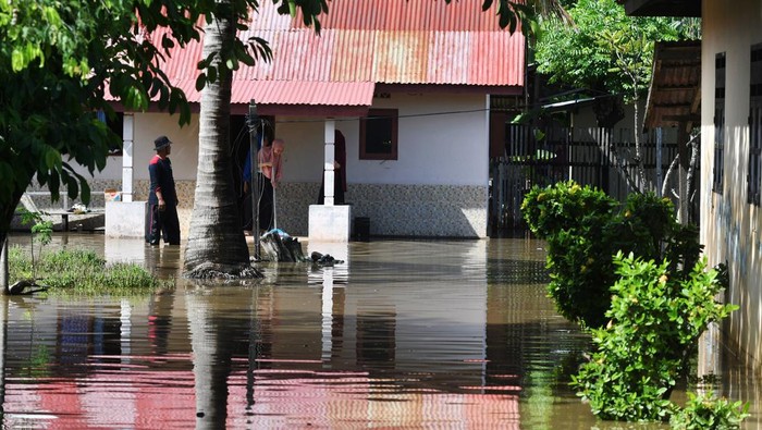 Warga berada di rumahnya yang terendam banjir di Palu, Sulawesi Tengah, Sabtu (12/3/2022). Hujan disertai angin kencang yang melanda daerah tersebut mengakibatkan sejumlah rumah warga terendam banjir, pohon tumbang dan satu bangunan sekolah rusak. ANTARA FOTO/Mohamad Hamzah/rwa.