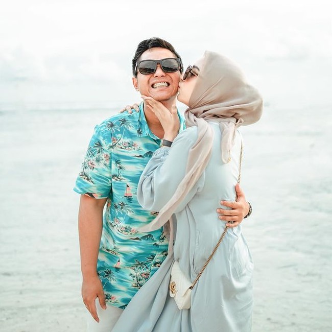 Liburan ke pantai bersama Doni Salmanan, Dinan tampil feminin dengan long dress biru dan tas Gucci GG Marmont mini matelassé yang harganya belasan juta rupiah. Foto: Instagram @dinanfajrina