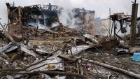 Petugas Damkar menyemprotkan air ke pabrik sepatu yang hancur setelah serangan udara di Dnipro, Jumat (11/3/2022) waktu setempat.