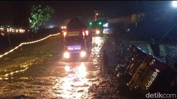 Sebuah dump truk terguling tepat di lokasi jalan amblas Tomo, Sumedang, Sabtu (11/3/2022) malam.
