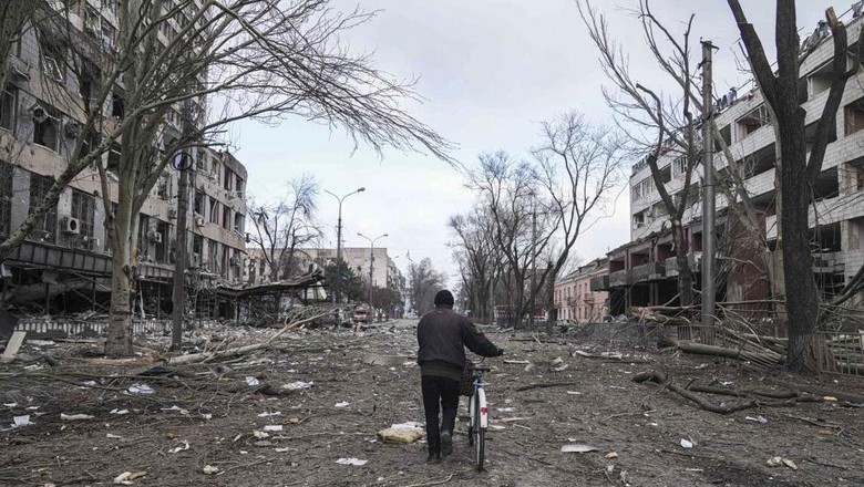 Situasi kehancuran di kota Mariupol, Ukraina, yang kini dikepung pasukan Rusia A man walks with a bicycle in a street damaged by shelling in Mariupol, Ukraine, Thursday, March 10, 2022. (AP Photo/Evgeniy Maloletka)