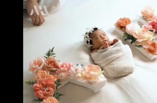 Nggak kalah lucu dan menggemaskan, kalau di pemotretan yang satu ini baby Ameena terlihat tengah tertidur di tengah-tengah tulisan A dan H. Dengan kepala yang dihiasi dari bandana yang terbuat dari bunga-bunga berwarna putih, baby Ameena berhasil bikin gemas. Foto: YouTube/AH