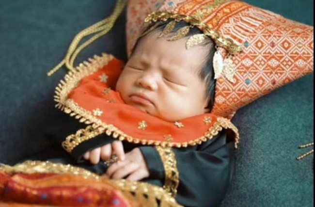 Memiliki darah Minang dari sang ayah, baby Ameena juga nggak lupa melakukan pemotretan dengan menggunakan baju adat Minang lengkap dengan penutup kepala. Ketika difoto, puutri pertama Atta Halilintar dan Aurel Hermansyah itu tampak mengerutkan dahinya. Foto: YouTube/AH