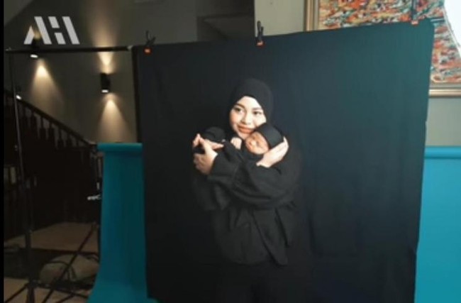 Melalui salah satu unggahan video di YouTube milik Atta Halilintar, dirinya terlihat membagikan momen saat sang anak, baby Ameena melakukan pemotretan. Dalam pemotretan itu baby Ameena tampak begitu menggemaskan, seperti ketika saat digendong oleh sang bunda. Keduanya kompak mengenakan pakaian serba hitam. Foto: YouTube/AH