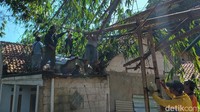 Warga dibantu anggota TNI memperbaiki rumah warga yang tertimpa pohon bambu.