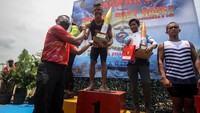 Komandan Pasmar 2 Brigjen TNI (Mar) Suherlan menyerahkan piala kepada pemenang lomba dayung perahu naga dalam rangka HUT ke-21 Pasmar 2, di Long Storage Kalimati Desa Kwatu, Mojoanyar, Mojokerto, Jawa Timur.