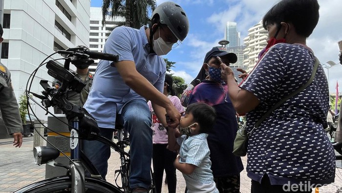 Gubernur DKI Jakarta Anies Baswedan tampak disambut warga saat mengunjungi JPO Pinisi Sudirman, Jakarta, Minggu (13/3). Anies sempat mencium tangan seorang anak.
