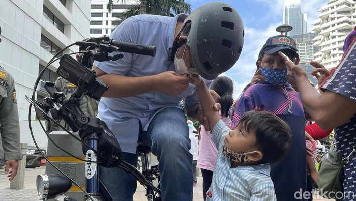 Gubernur DKI Jakarta Anies Baswedan tampak disambut warga saat mengunjungi JPO Pinisi Sudirman, Jakarta, Minggu (13/3). Anies sempat mencium tangan seorang anak.