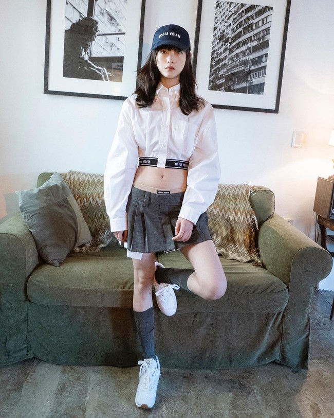 Berbeda dengan dua artis Korea lain, Lee Yoo Mi memakai versi tanpa ikat pinggang dan memadukan rok mini dengan kemeja crop top dan topi. Pemain Squid Game yang di-endorse Miu Miu tersebut terlihat boyish sekaligus sporty. Foto: Instagram