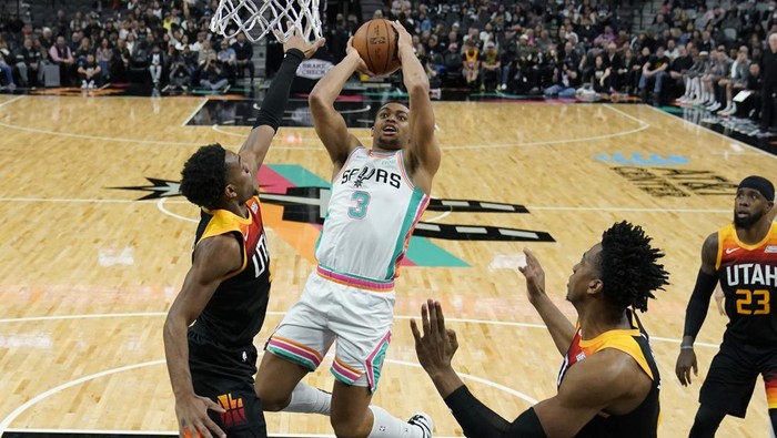 San Antonio Spurs forward Keldon Johnson (3) shoots over Utah Jazz guard Trent Forrest, left, during the first half of an NBA basketball game, Friday, March 11, 2022, in San Antonio. (AP Photo/Eric Gay)