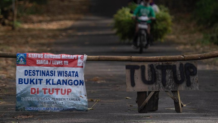 Warga melintas usai mencari rumput di Bukit Klangon, Glagaharjo, Cangkringan, Sleman, DI Yogyakarta, Minggu (13/3/2022). Berdasarkan rekomendasi Balai Penyelidikan dan Pengembangan Teknologi Kebencanaan Geologi (BPPTKG), Pemerintah Kabupaten Sleman menutup sementara sejumlah destinasi wisata yang berada dalam radius lima kilometer dari puncak Gunung Merapi pasca awan panas guguran pada Rabu (9/3). ANTARA FOTO/Hendra Nurdiyansyah/foc.
