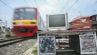 Tampak kereta melintas di samping perabot yang belum diangkut pemiliknya.