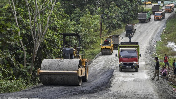 Pekerja dibantu alat berat memperbaiki Jalan Semboja-Sepaku yang sempat rusak di Kecamatan Samboja, Kutai Kartanegara, Kalimantan Timur, Minggu (13/3/2022). Jalan tersebut merupakan akses menuju Ibu Kota Negara (IKN) Nusantara dari Kota Balikpapan, Kalimantan Timur. ANTARA FOTO/Hafidz Mubarak A/hp.