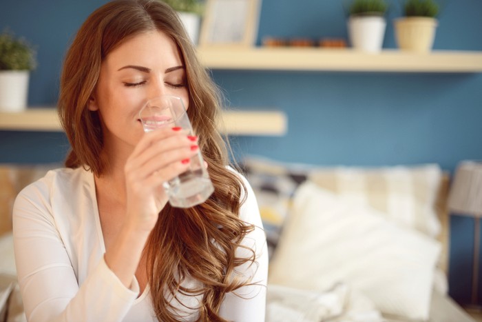 beautiful young woman holding a glass of water
