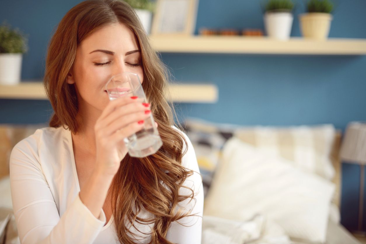 beautiful young woman holding a glass of water