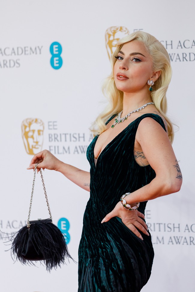 Turut melengkapi gayanya, tas mungil berbulu yang mempertegas rasa glamor ala Old Hollywood. (Foto: Getty Images/Tristan Fewings)