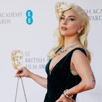 Turut melengkapi gayanya, tas mungil berbulu yang mempertegas rasa glamor ala Old Hollywood. (Foto: Getty Images/Tristan Fewings)