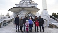 Imam masjid Mehmet Yuci memegang bendera Turki bersama sebagian pengungsi di sebuah masjid di Sabtu, (12/2/2022). Kedubes Turki di Ukraina menyebutkan, terdapat 86 warganya yang berada di masjid tersebut menunggu proses evakuasi, 34 diantaranya anak-anak. 