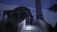 Imam masjid Mehmet Yuce menuruni tangga usai Salat Maghrib, di sebuah masjid di Kota Mariupol, Ukraina, Sabtu, (12/2/2022). 86 warga negara Turki berada di masjid itu sambil menunggu proses evakuasi di antara dentuman rudal Rusia setiap hari.
