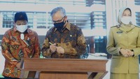 Ketua Dewan Komisioner (DK) Otoritas Jasa Keuangan (OJK) Wimboh Santoso (tengah) menandatangani prasasti didampingi Wali Kota Batu Dewanti Rumpoko (kanan) dan anggota DPR Komisi XI Andreas Eddy Susetyo (kiri) saat peresmian Kantor Otoritas Jasa Keuangan, Malang, Jawa Timur, Senin (14/3/2022).