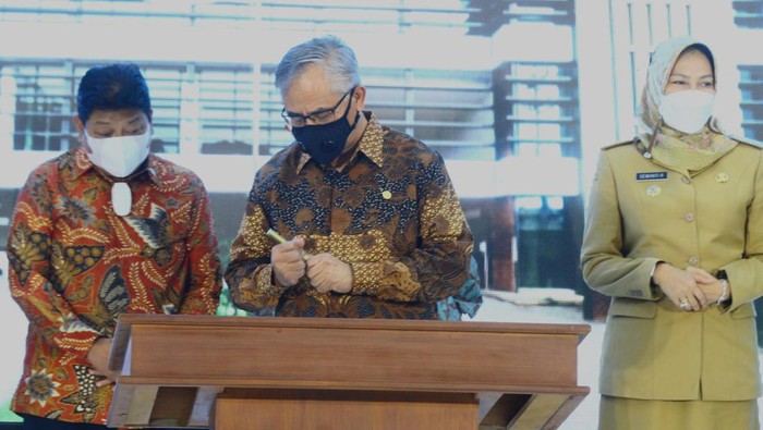 PERESMIAN KANTOR OJK DI MALANG Ketua Dewan Komisioner (DK) Otoritas Jasa Keuangan (OJK) Wimboh Santoso (tengah) menandatangani prasasti didampingi Wali Kota Batu Dewanti Rumpoko (kanan) dan anggota DPR Komisi XI Andreas Eddy Susetyo (kiri) saat peresmian Kantor Otoritas Jasa Keuangan, Malang, Jawa Timur, Senin (14/3/2022). Melalui kantor baru OJK Malang tersebut, OJK berharap dapat lebih meningkatkan pemahaman dan edukasi terkait masalah keuangan pada masyarakat sehingga mampu menumbuhkan perekonomian di daerah. ANTARA FOTO/Ari Bowo Sucipto/aww.