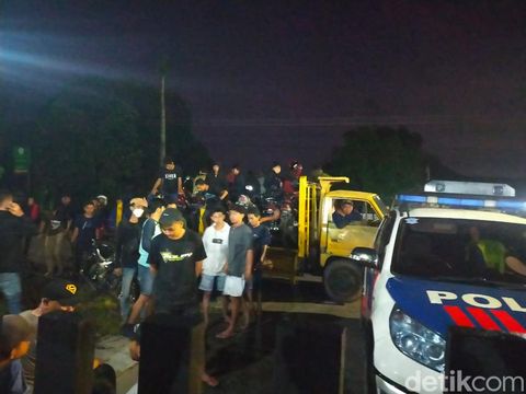 Salah satu pemotor mencemplungkan motornya ke sawah untuk menghindari razia balap liar