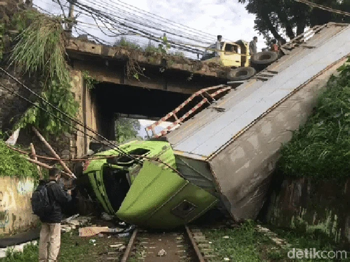 Truk muatan susu kaleng terperosok di jembatan perlintasan kereta api.