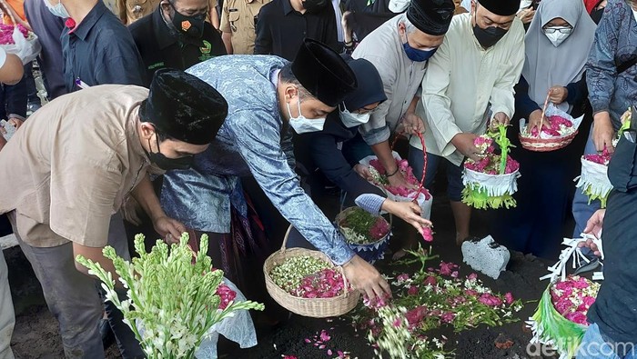 Wali Kota Surabaya Eri Cahyadi dan istrinya menaburkan bunga di pusara ayah mertuanya.