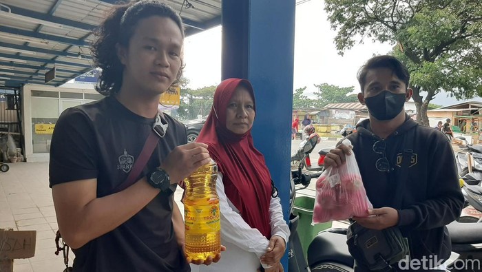 Warga membeli minyak goreng yang dipaketkan dengan buah di Kendari, Sultra.